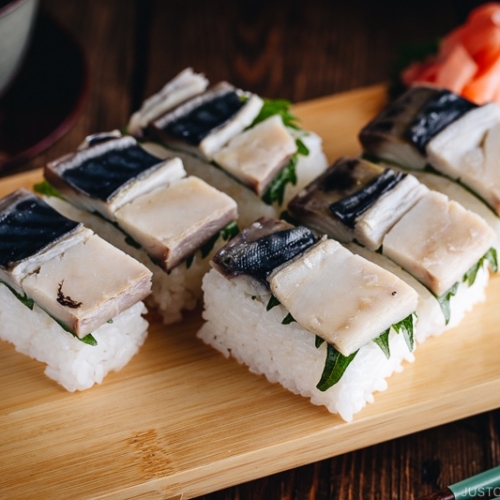 Makrelen-Press-Sushi (Saba Oshizushi) und Sushi-Ingwer liegen auf dem Bambus-Sushi-Tablett.