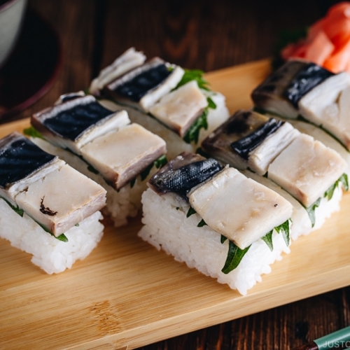 Mackerel Pressed Sushi (Saba Oshizushi) and sushi ginger are on the bamboo sushi tray.