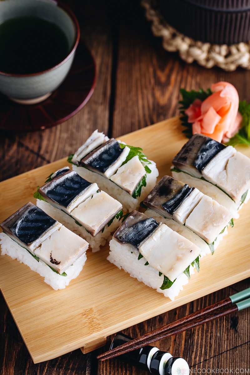 Il sushi pressato di sgombro (Saba Oshizushi) e lo zenzero sushi sono sul vassoio del sushi di bambù.