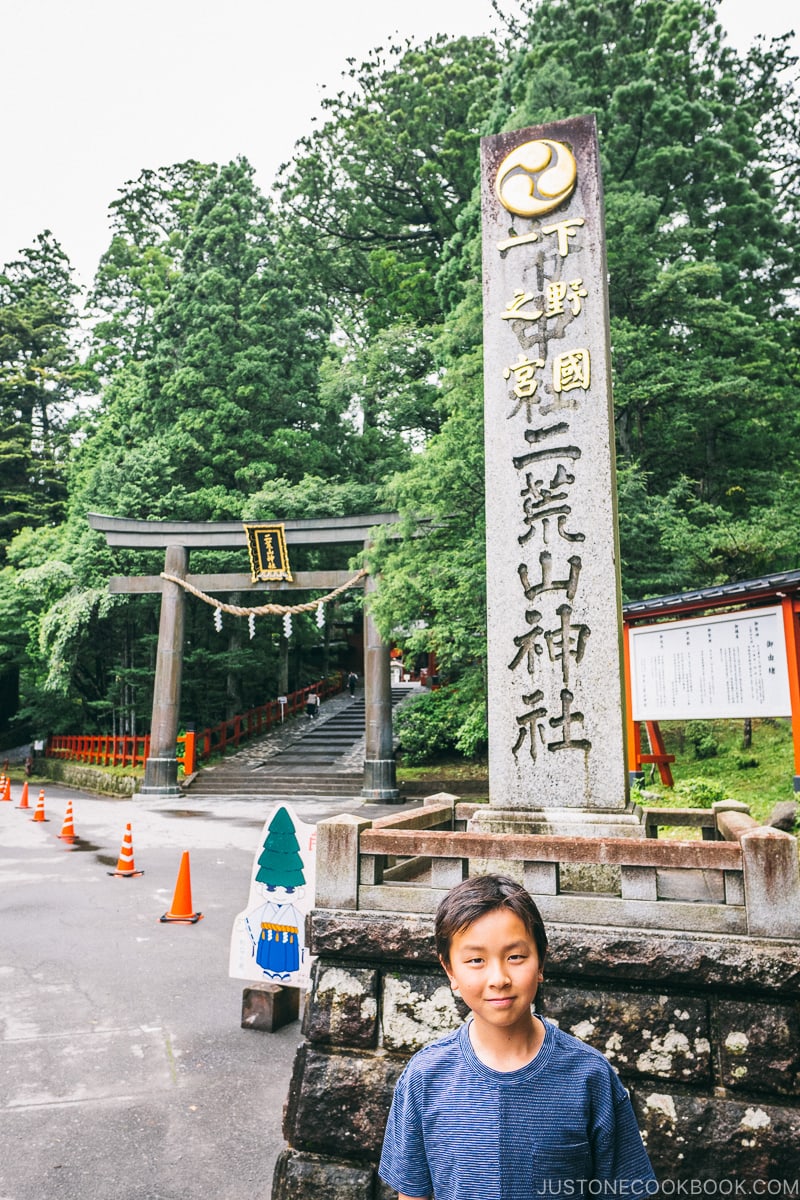 child standing in front of Nikko Futarasan Jinja stone monument - Places to Visit and Things to do in Nikko | www.justonecookbook.com