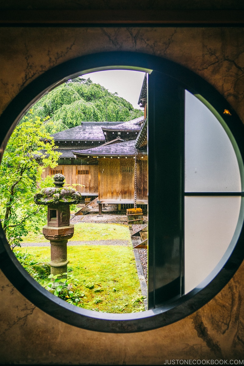 looking through a circle window into the garden at Nikko Tamozawa Imperial Villa Memorial Park - Places to Visit and Things to do in Nikko | www.justonecookbook.com