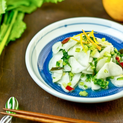 Pickled Turnip with Yuzu on a blue plate.