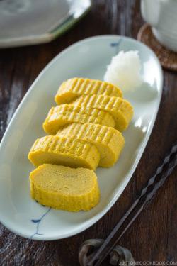 Tamagoyaki and grated daikon on a white plate.