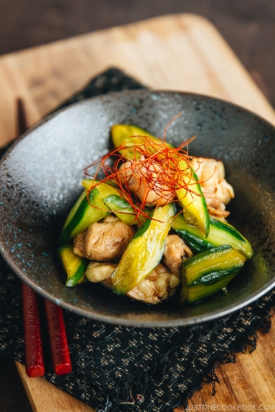 A black ceramic bowl containing Cucumber and Chicken Marinated in Chili Oil.