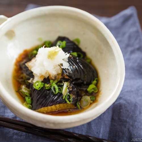 A white ceramic bowl containing eggplant agebitashi.