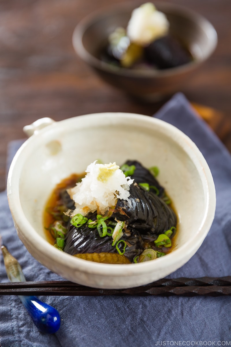 A white ceramic bowl containing eggplant agebitashi.