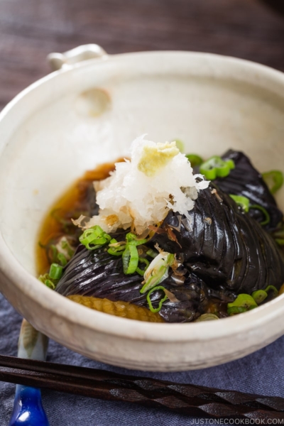 A white ceramic bowl containing eggplant agebitashi.