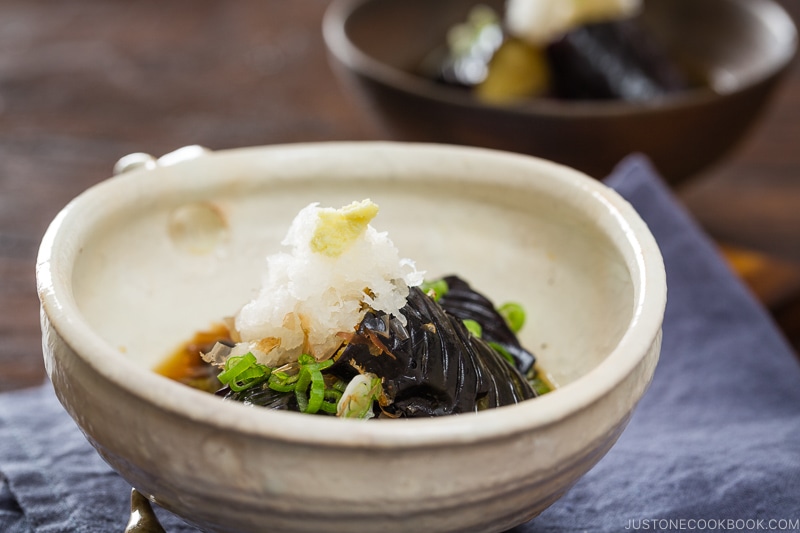 A white ceramic bowl containing eggplant agebitashi.