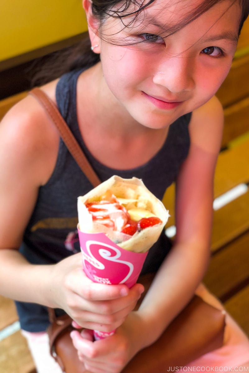 girl getting ready to eat crepe on a bench - Insiders' Guide for For First Time Visitors to Japan | www.justonecookbook.com