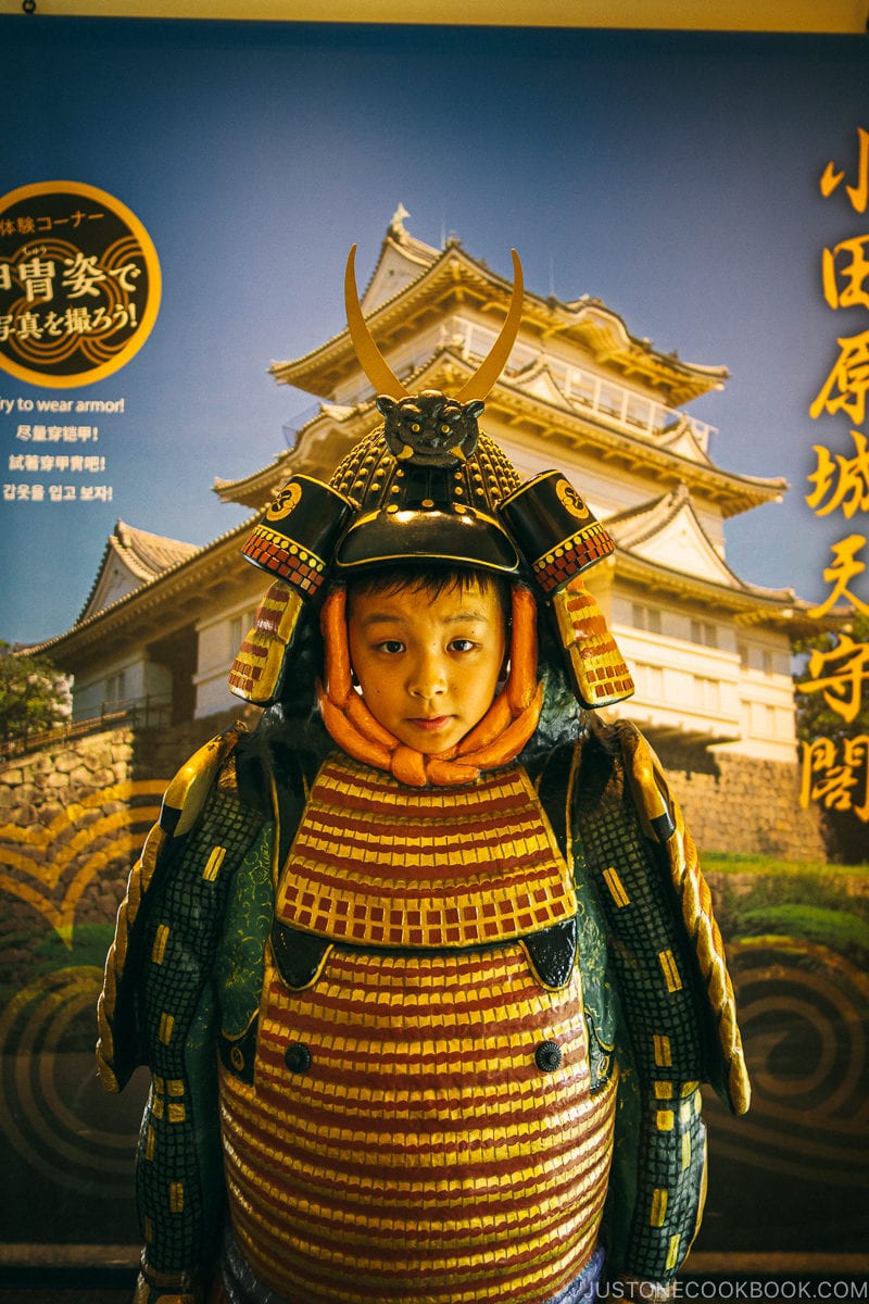 boy standing behind armor and kabuto helmet - Odawara Castle Guide | www.justonecookbook.com 