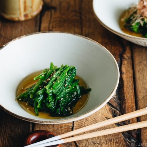 Spinach ohitashi in white ceramic plates.