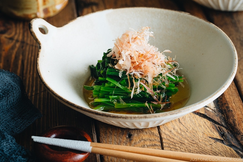 Spinach ohitashi in white ceramic plates.