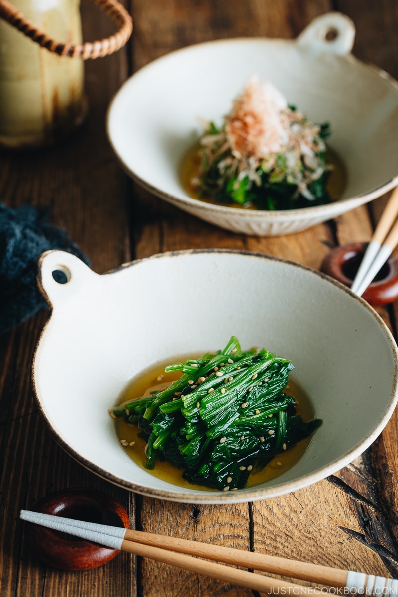 Spinach ohitashi in white ceramic plates.