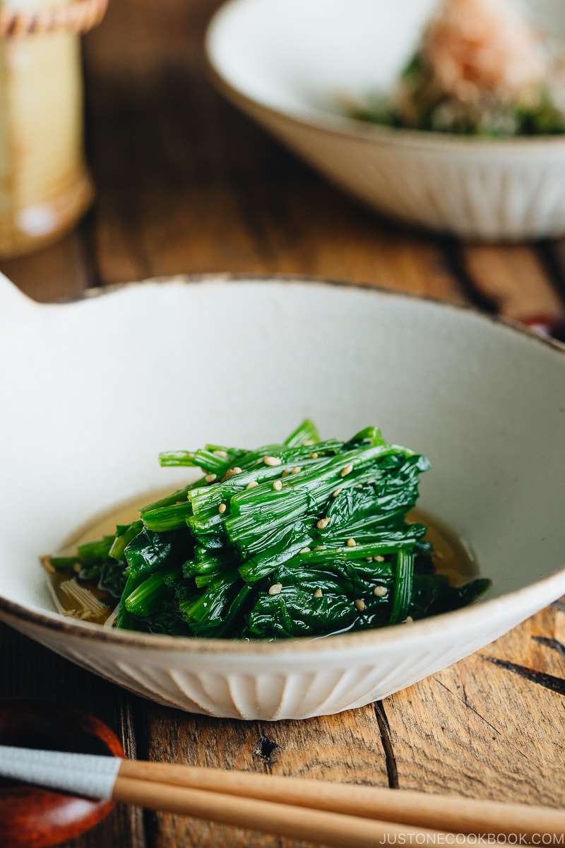 Spinach ohitashi in white ceramic plates.