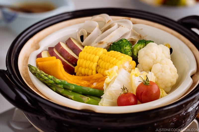 Steamed vegetables on donabe steamer along with dipping sauce.