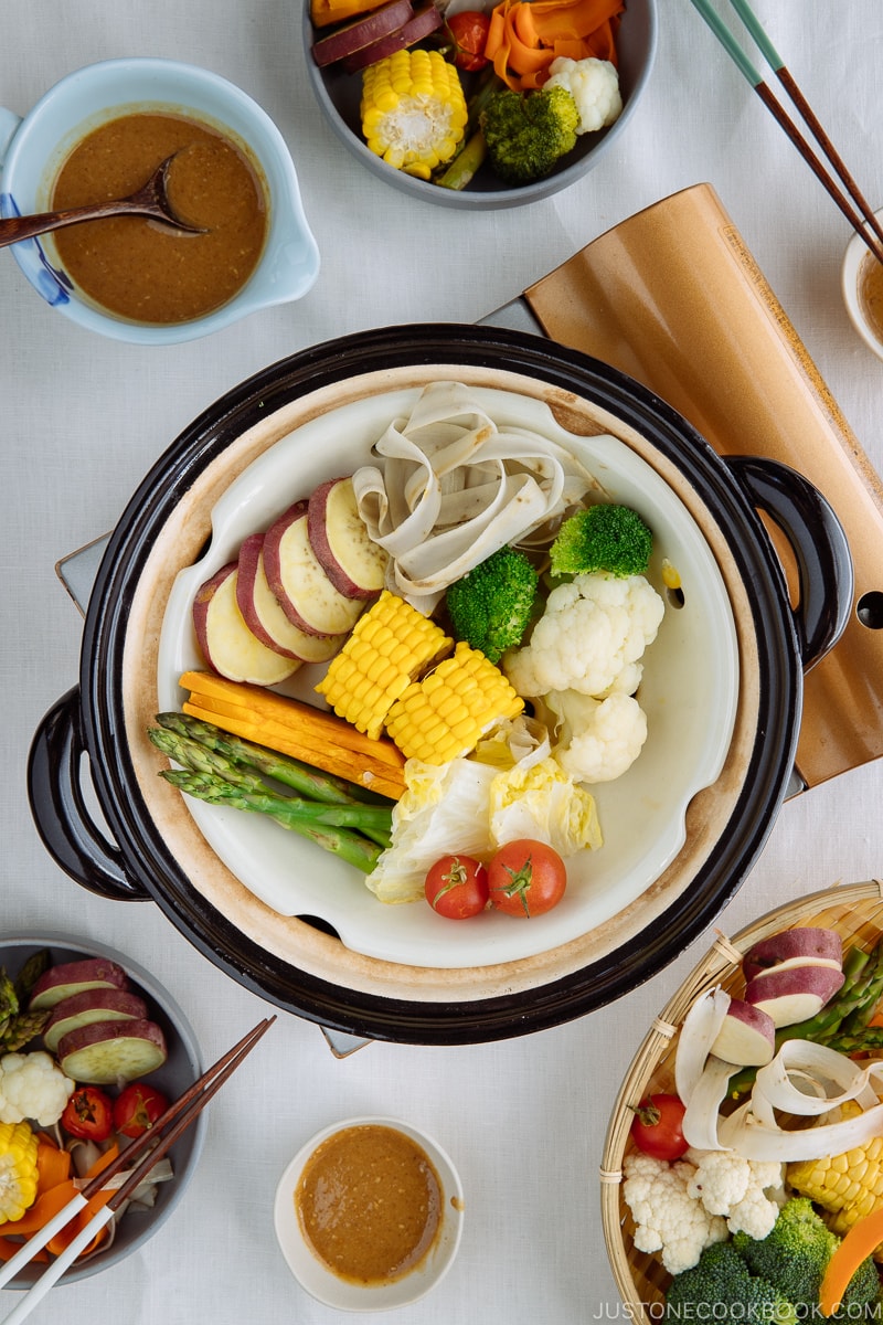 Steamed vegetables on donabe steamer along with dipping sauce.