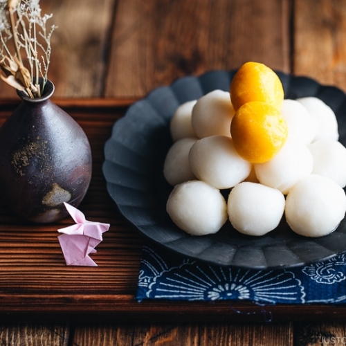 Tsukimi Dango on a black plate.