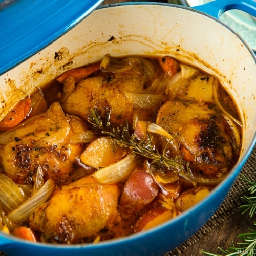 Dutch oven containing braised chicken and vegetables.