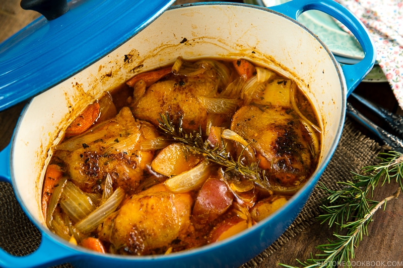 Dutch oven containing braised chicken and vegetables.