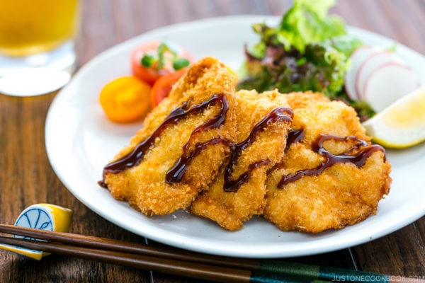 Chicken katsu served on a plate along with spring salad.