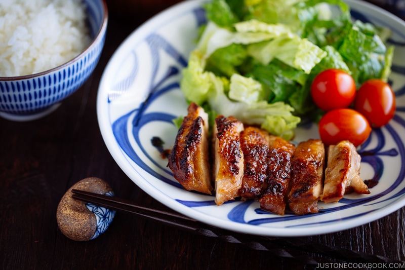 Chicken teriyaki served with salad on a plate.