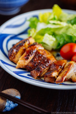 Chicken teriyaki served with salad on a plate.