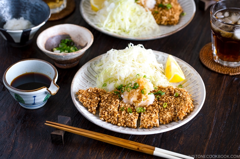 GlutGluten Free Baked Chicken Katsu with cabbage salad and sliced lemon on the plate.