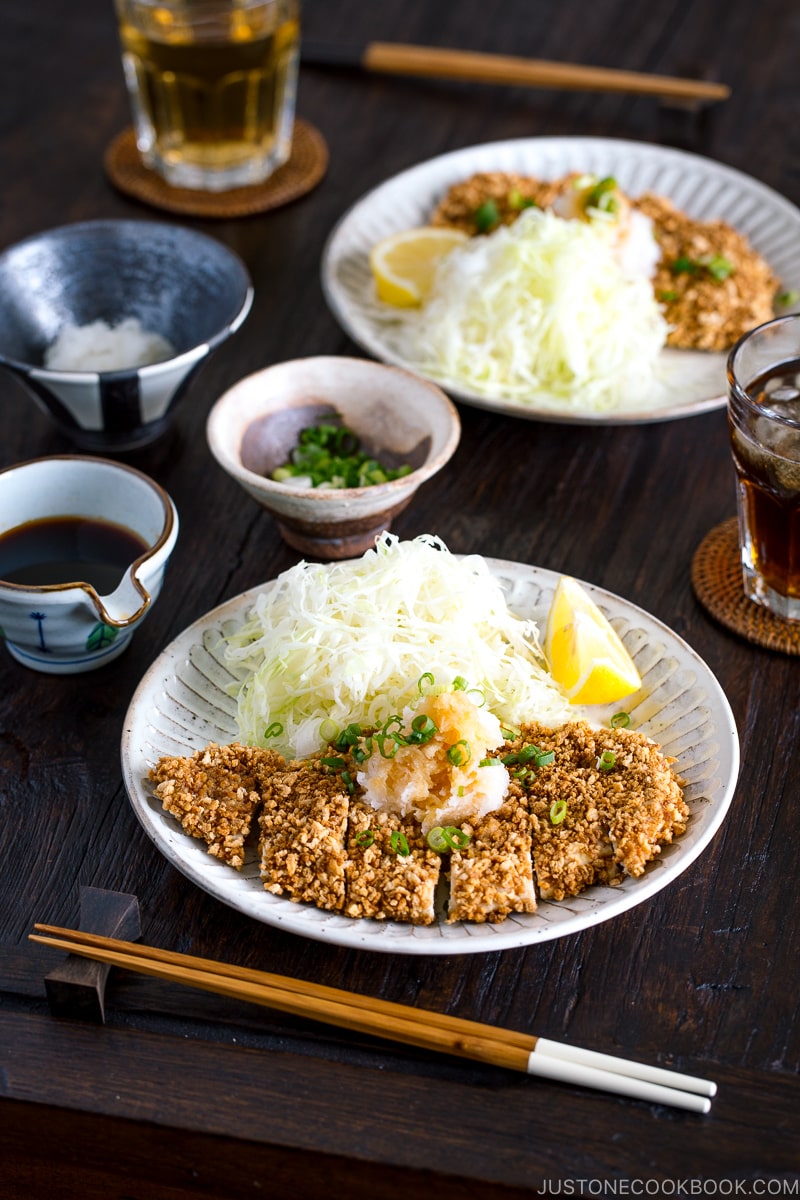 GlutGluten Free Baked Chicken Katsu with cabbage salad and sliced lemon on the plate.