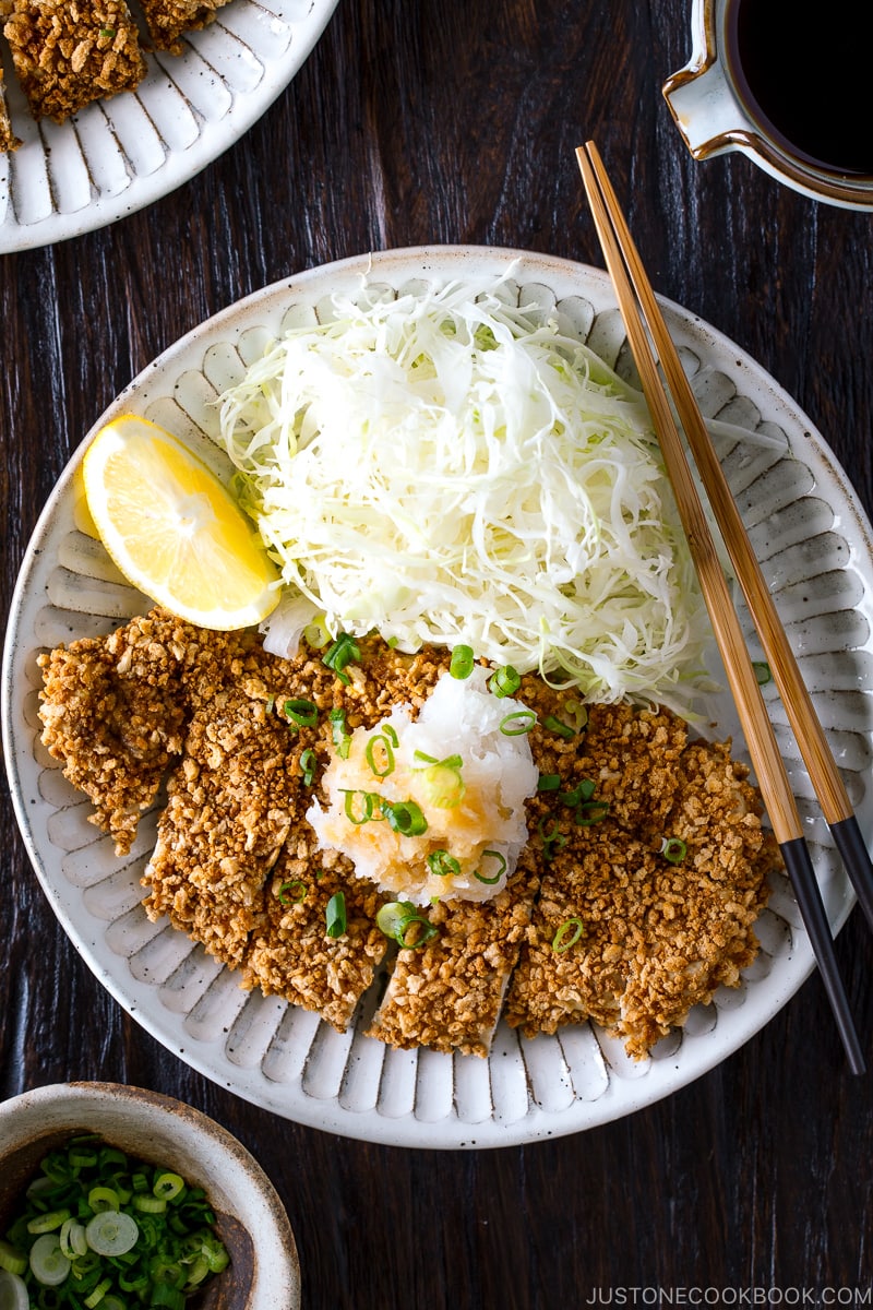 GlutGluten Free Baked Chicken Katsu with cabbage salad and sliced lemon on the plate.