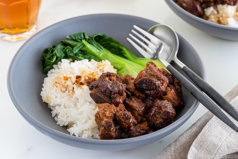 Instant pot honey spare ribs served with rice and steamed bok choy in a grey ceramic bowl.