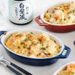 Creamy macaroni gratin served in blue and red STAUB gratin dishes.
