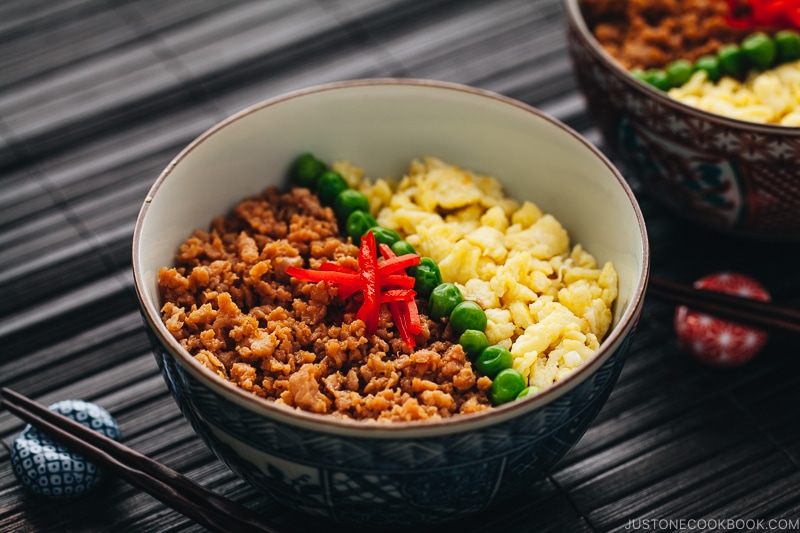 The Japanese bowls containing seasoned ground chicken, scramble eggs, and green veggies.