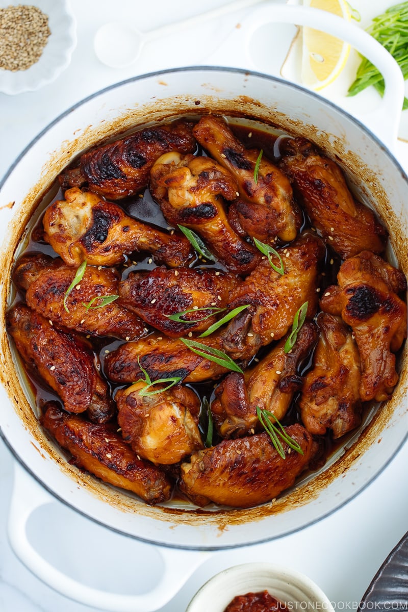 Teriyaki wings in a white Le Creuset pot.