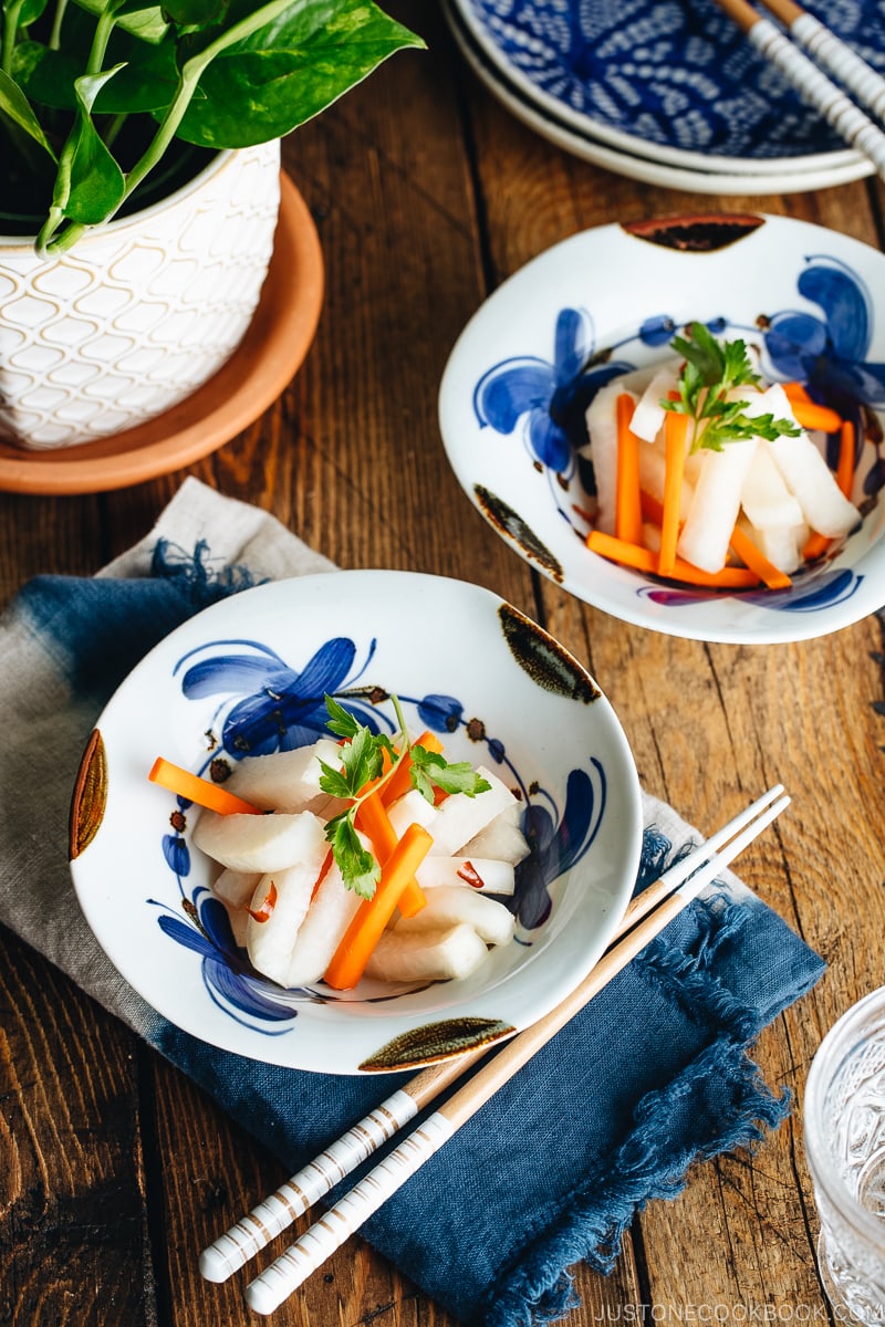 Daikon and carrot pickled in sweet vinegar, served in Japanese ceramic bowls.