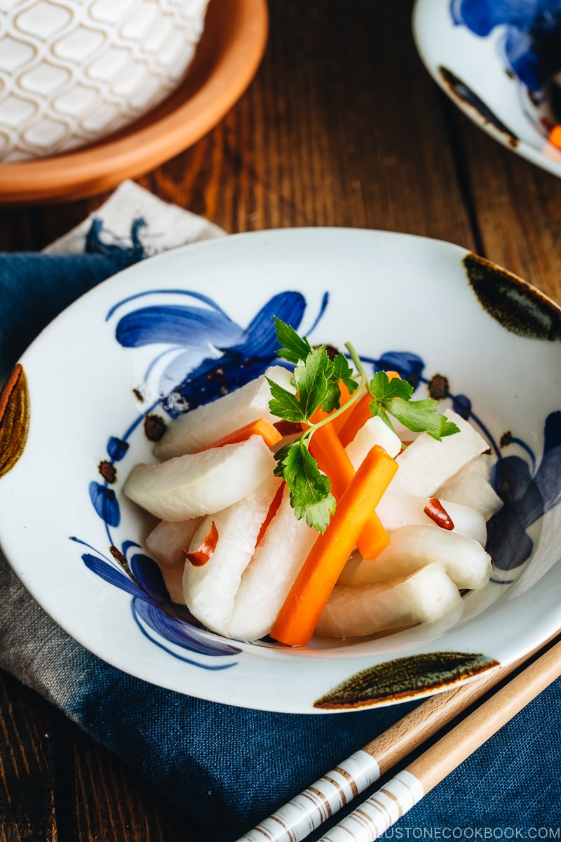 Daikon and carrot pickled in sweet vinegar, served in Japanese ceramic bowls.