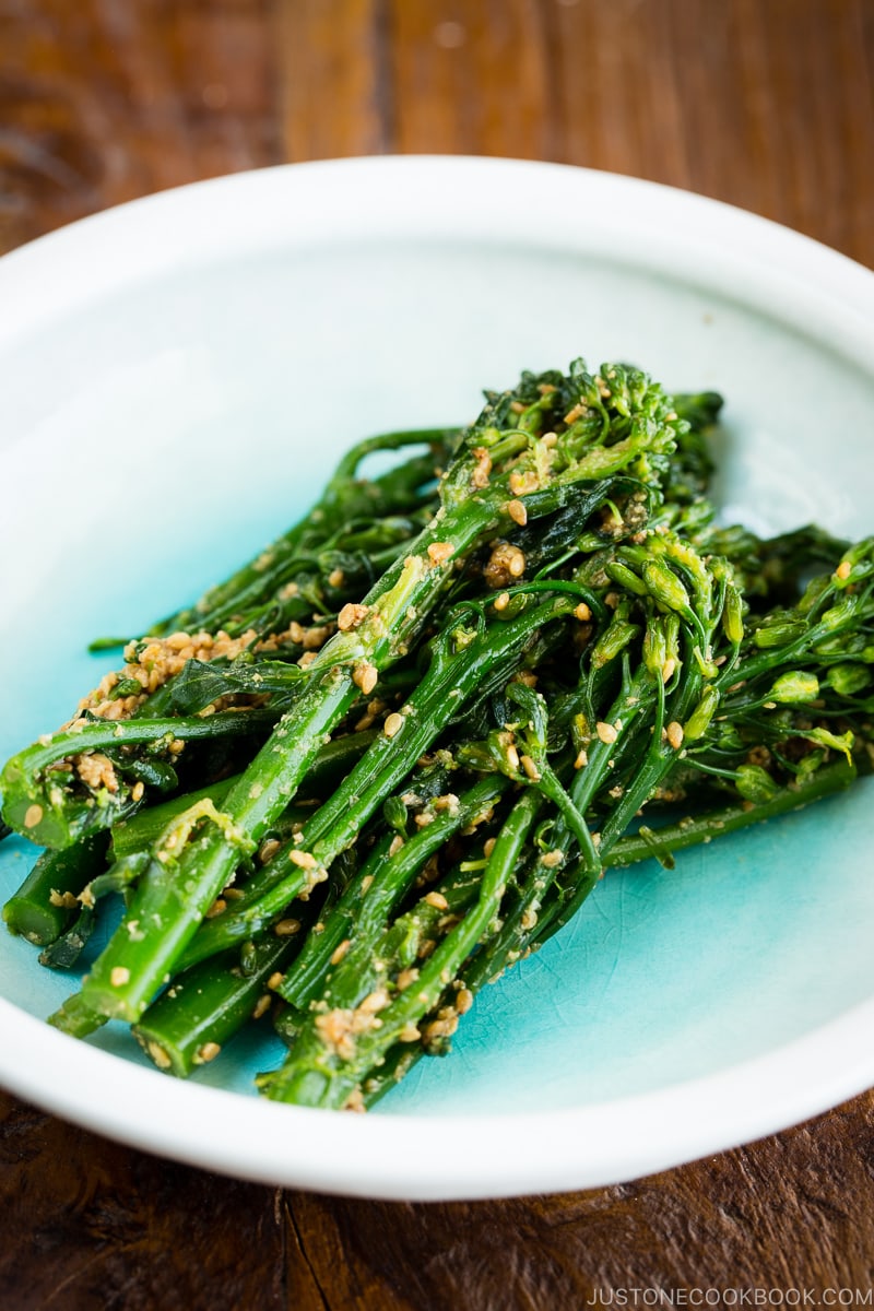 A plate containing broccolini dressed in the Japanese style sesame sauce.