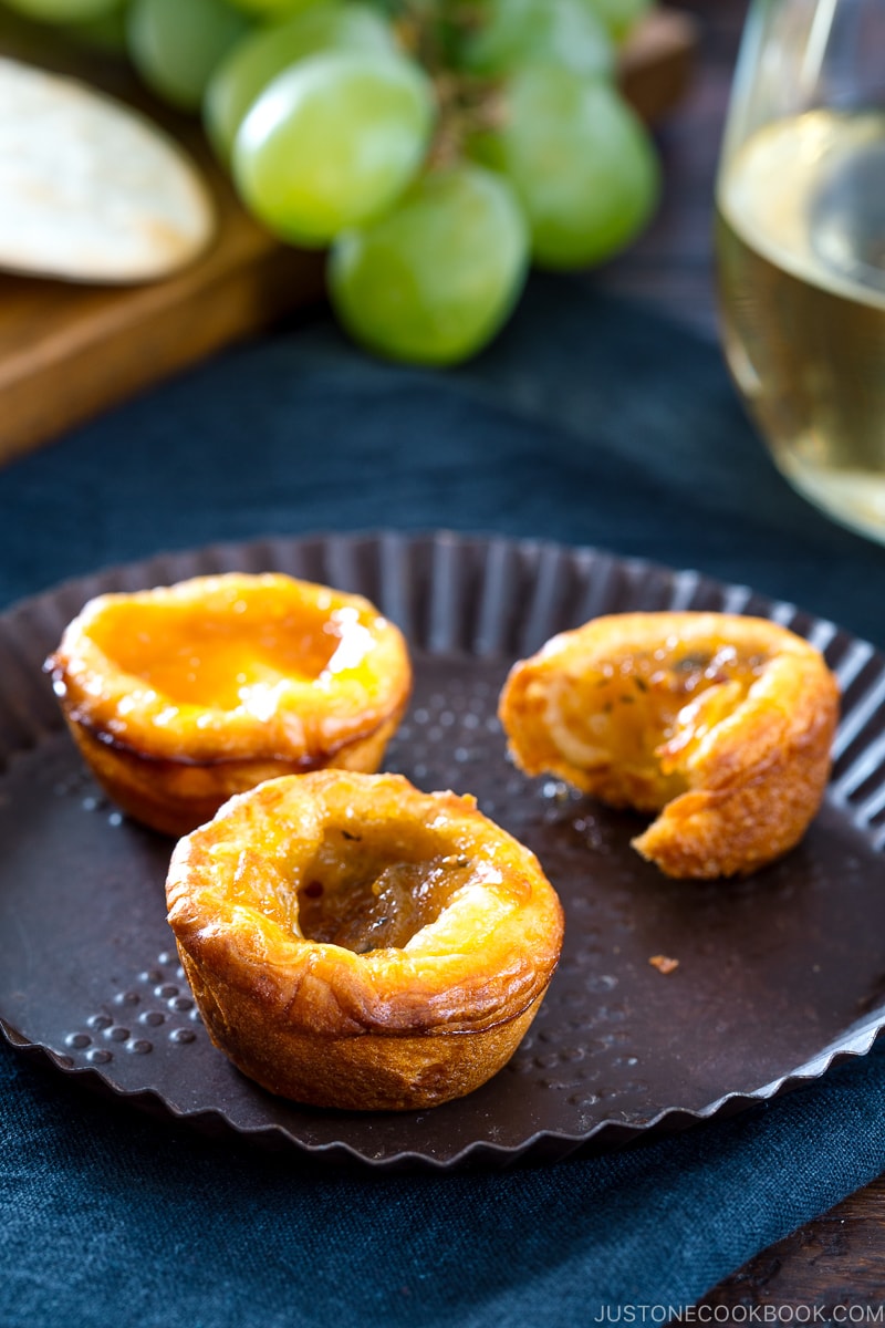 A plate containing cheese tart made with crescent roll and filled with brie cheese and fruit preserves.