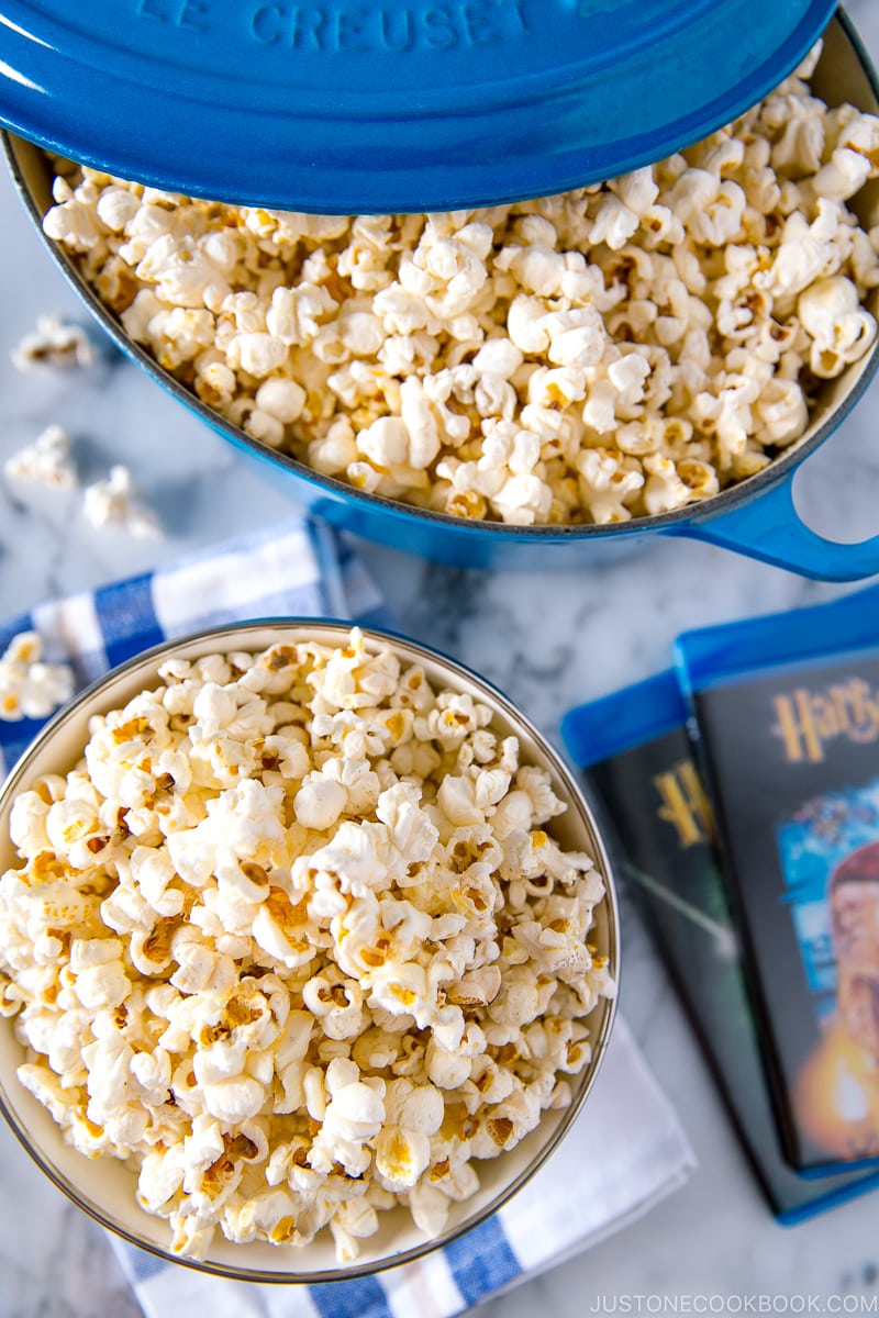 A bowl and Dutch oven containing popcorn with truffle salt seasoning.