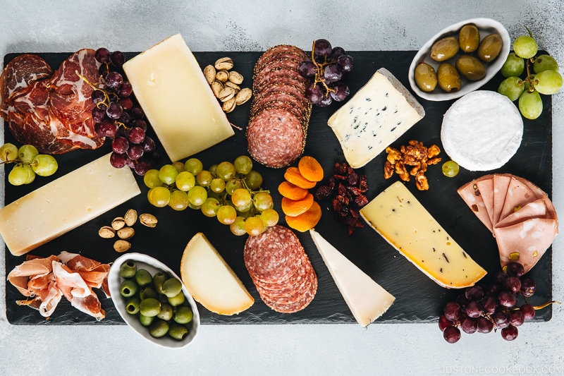 Cheese, fruits, and Charcuterie on a black slate board