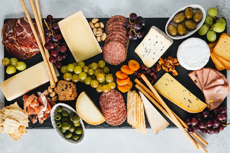 Cheese, fruits, and Charcuterie on a black slate board