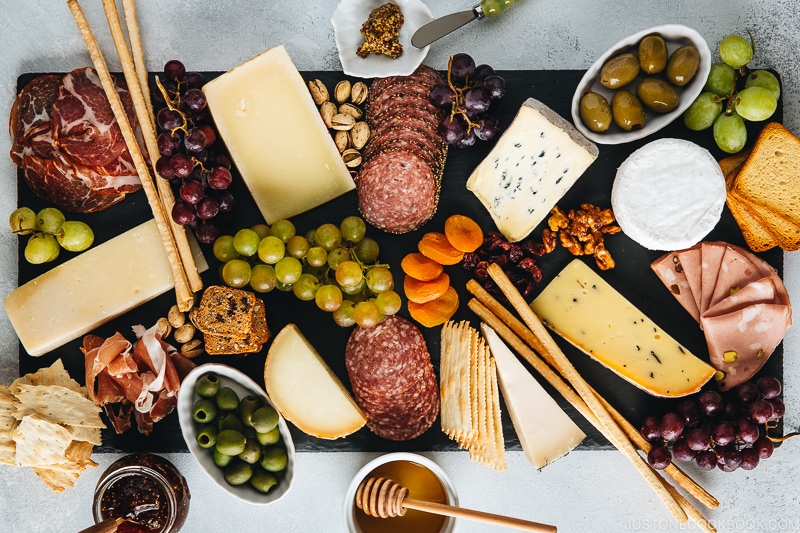 Cheese, fruits, and Charcuterie on a black slate board