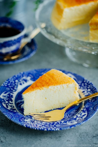 Cheesecake being served on a blue plate.