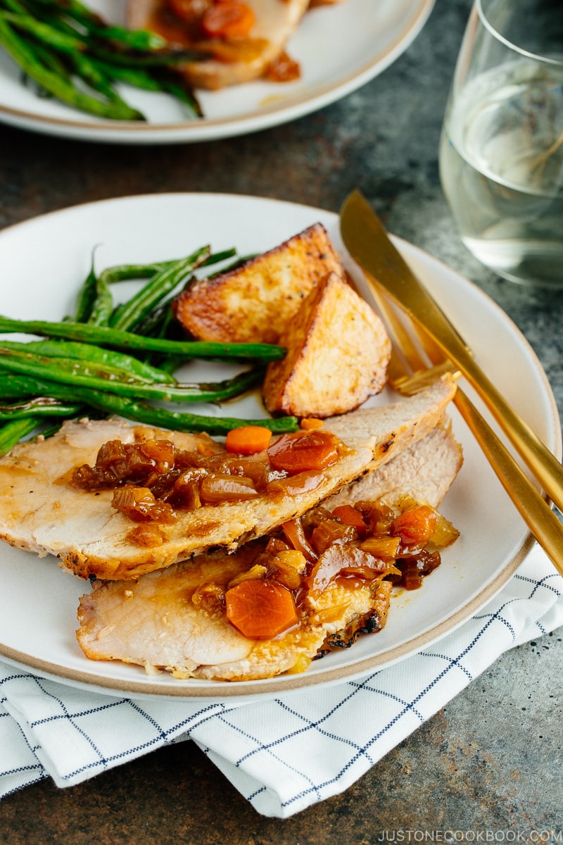 Plates containing sliced Japanese Pork Roast, green beans, and roasted potatoes.