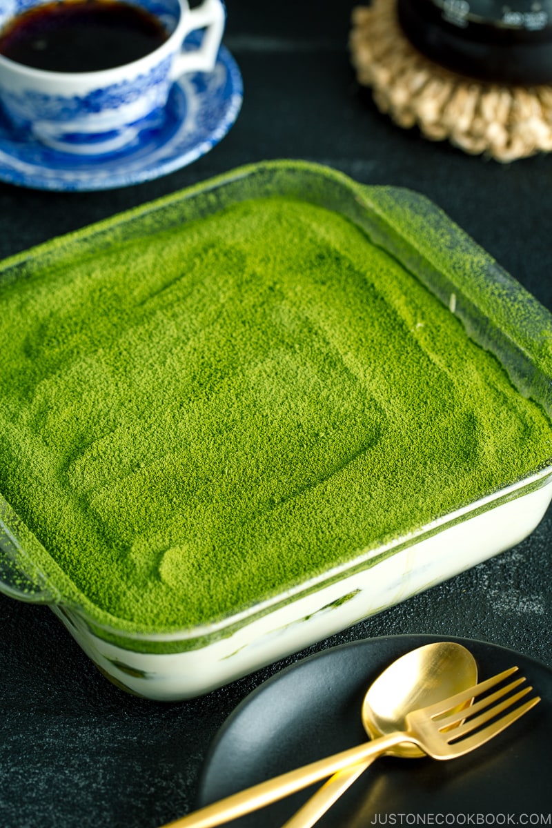 matcha tiramisu cake made with soaked ladyfingers and mascarpone custard filling.