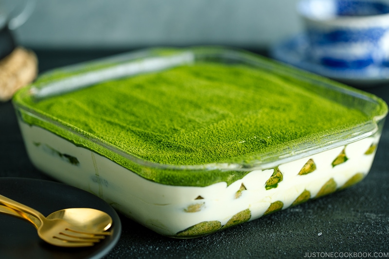 matcha tiramisu cake made with soaked ladyfingers and mascarpone custard filling.