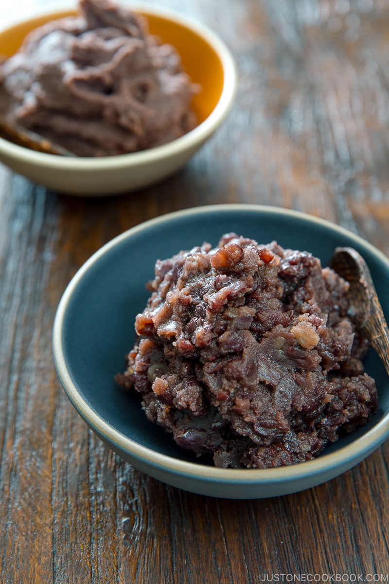 Two bowls containing fine and chunky sweet red bean paste (anko).