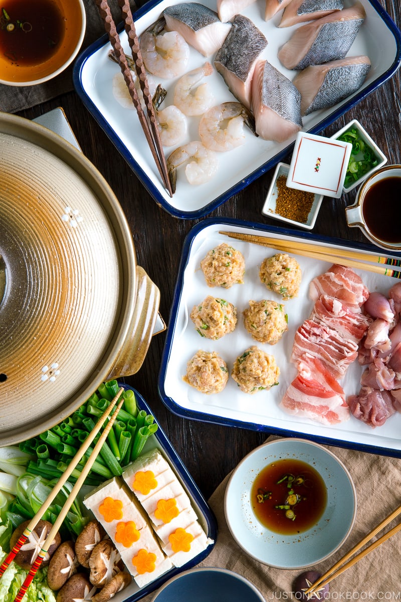 A dining table filled with Chanko Nabe ingredients and a donabe hot pot.