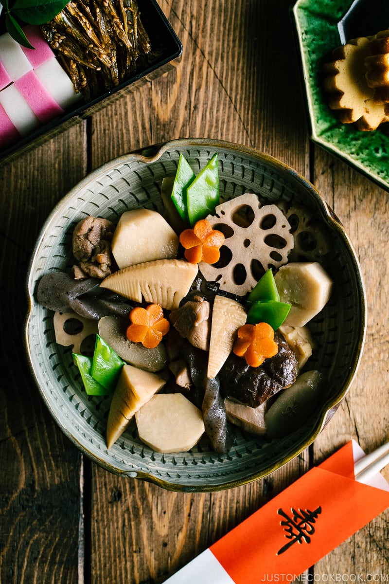 A Japanese ceramic bowl containing simmered chicken and vegetables.