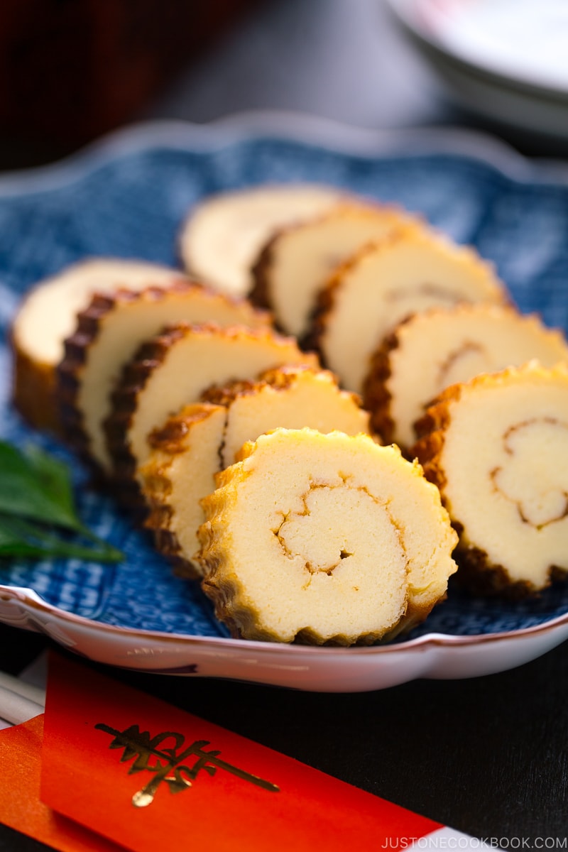 Japanese blue ceramic plate containing slices of Datemaki (Sweet Rolled Omelette)