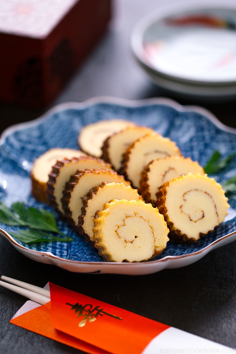 Japanese blue ceramic plate containing slices of Datemaki (Sweet Rolled Omelette)
